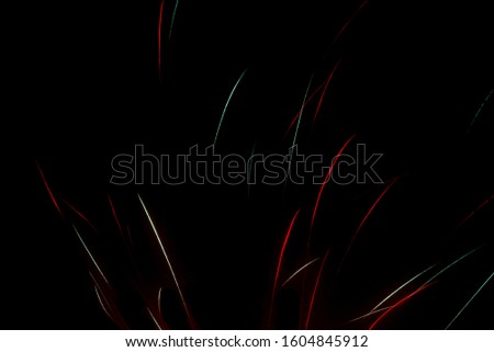 Colorful blur abstract green and red fireworks lines against black background, vivid color illustration