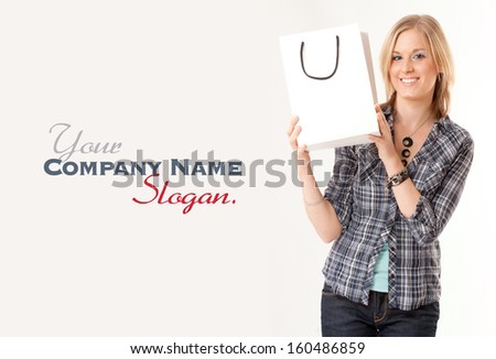 Young blonde woman happily holding a shopping bag against a white background 