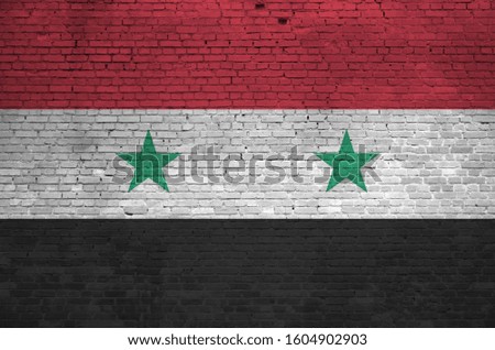 Syria flag depicted in paint colors on old brick wall. Textured banner on big brick wall masonry background