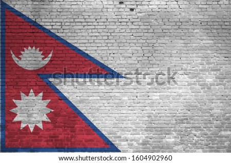 Nepal flag depicted in paint colors on old brick wall. Textured banner on big brick wall masonry background
