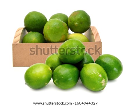 Fresh ripe lime isolated in wooden crate on white background