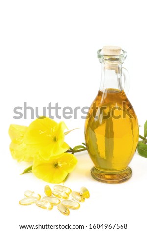evening primroses with gelatine capsules and oil bottle on white background Royalty-Free Stock Photo #1604967568