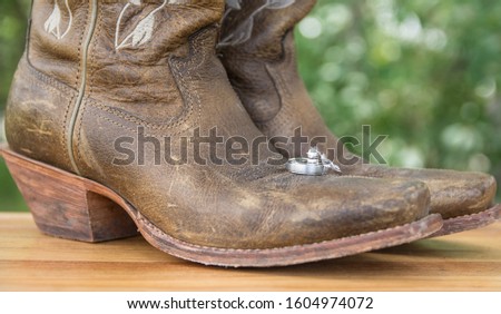 Wedding rings placed on cowboy boots
