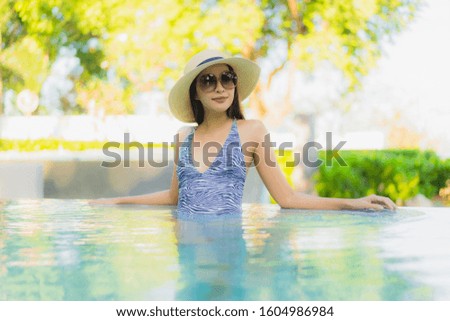 Beautiful young asian women happy smile relax around outdoor swimming pool in hotel resort neary sea beach for travel in holiday vacation