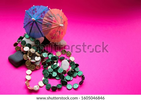 beads and beach cocktails on the rock ready for vacation on a pink background