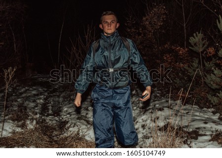 Male hikers in clothes for hiking and flashlights on winter mountain at night.