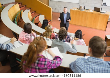 Elegant teacher with students sitting at the college lecture hall Royalty-Free Stock Photo #160511186