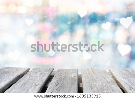 empty wooden table on the blurring background from Christmas tree, love hearts and festive lights
