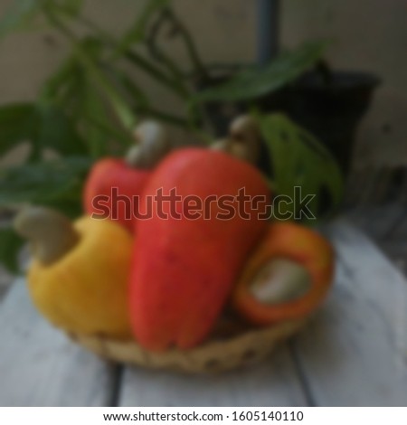 Blurry background of cashew fruits, also called cashew apples, along with cashew nuts.tropical fruits identity concept.