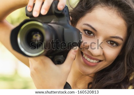 Gorgeous calm woman holding her camera smiling at camera