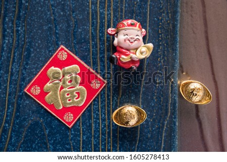 
Chinese New Year, decoration of God of Wealth, red envelope, gold ingot, calendar. The Chinese character translates as: "Spring and Blessings".