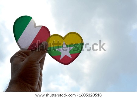 Hand holds a heart Shape Italy and Myanmar flag, love between two countries