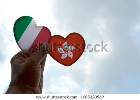 Hand holds a heart Shape Italy and Hong Kong flag, love between two countries