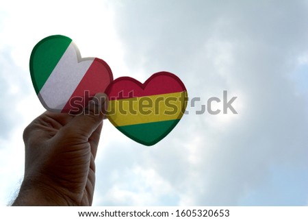 Hand holds a heart Shape Italy and Bolivia flag, love between two countries