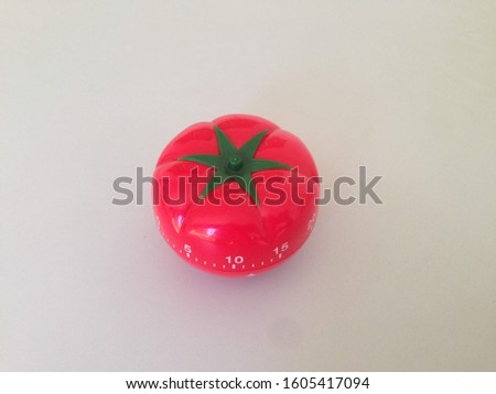 Pomodoro Timer red with green details. Tomato on the table. Vibrant, multi-angle colors.