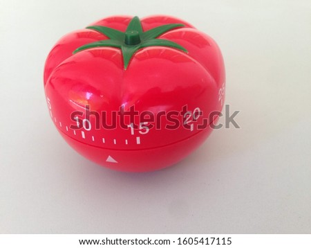 Pomodoro Timer red with green details. Tomato on the table. Vibrant, multi-angle colors.