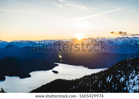 sunrise over snow-covered alps with view of the lake