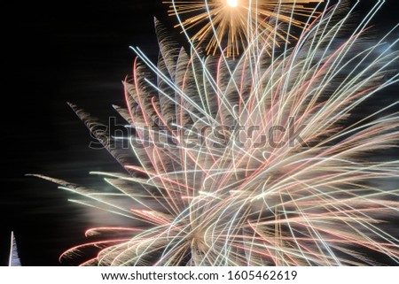 neon lighting from an aged photo of fireworks. abstract painting with bright multi-colored beams of lightning on a black background