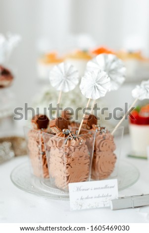 Mousse with almonds and hazelnuts, of dark chocolate in transparent plastic cup. Picture for a menu or confectionery catalog