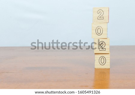 New 2020 year. Happy new year, greeting card template, 2020 on wooden cubes on wooden desk background. Selective focus.