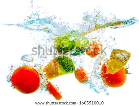 Fruits and vegetables fall into the water, consisting of pumpkin, carol, tomatoes in the juice concept