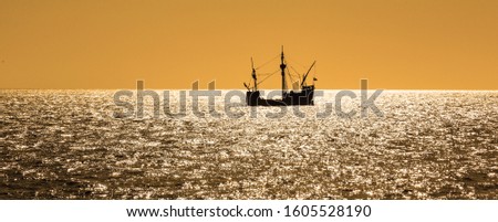 silhouette view of the Santa Maria tallship of Columbus, sailing the Atlantic ocean around Madeira island in summer at sunset