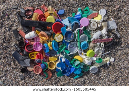 plastics thrown on the beach, spilled plastic garbage on the beach, dirty sea sandy shore
