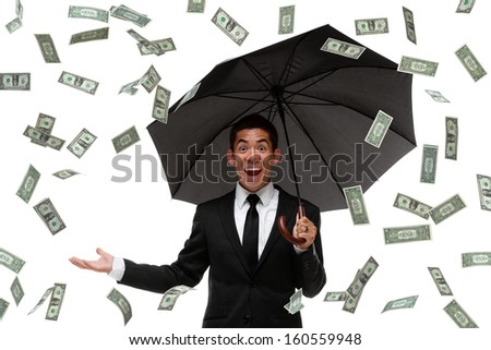 Excited businessman looking at camera in a money rain storm