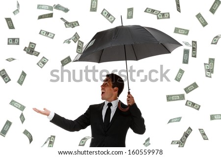 Excited businessman looking at camera in a money rain storm