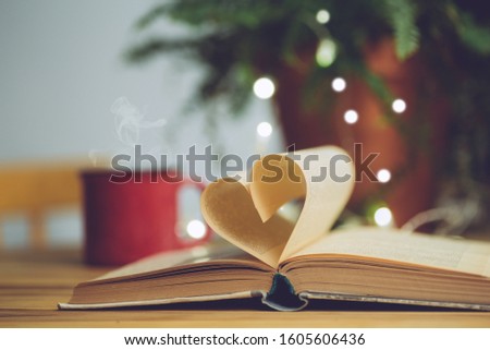 Love reading or Saint Valentine's Day background. Open book with a heart shape page. Knowledge, education or love concept. Royalty-Free Stock Photo #1605606436