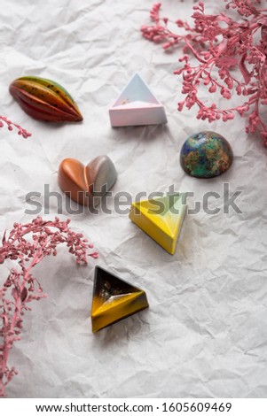 Chocolate candy collections and flowers on white paper