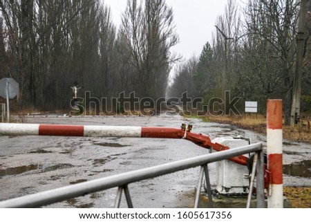 The barrier is blocking the road to Pripyat near the checkpoint at the entrance to the ghost town of Prypiat in Chornobyl Exclusion Zone, Ukraine. December 2019