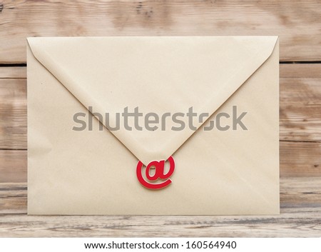 E-mail symbol and blank brown envelope on old wooden background . concept of E-Mail