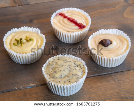 Top view of a group diffrent colorful cupcakes on a wooden background 