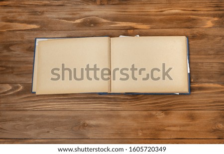 Old photo album with photos on a wooden table.Mockup free.Copy space.