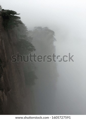 two straight mountains dissolving in fog
