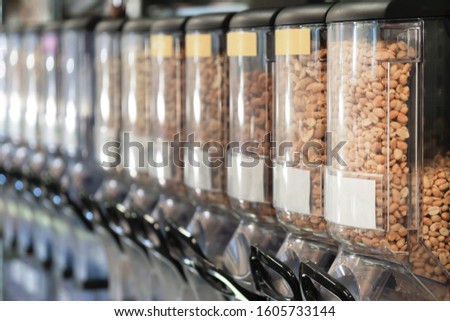 Dispensers with nuts in zero waste shop. New trend alternative buying. Concept healthy food background. Healthy vegan food. Zero waste, eco-friendly concept. Sustainable lifestyle concept. Royalty-Free Stock Photo #1605733144