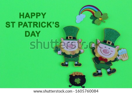 leprechauns holding mug of beer next to a black pot of gold and a rainbow with happy st Patricks day in green text on a green background