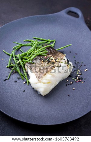 Gourmet fried Japanese skrei cod fish filet with glasswort and furikake as closeup on a modern design plate 