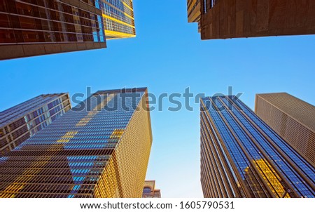 Bottom up Street view on Financial District of Lower Manhattan, New York City, NYC, USA. Skyscrapers tall glass buildings United States of America. Blue sky on background. Mixed media.
