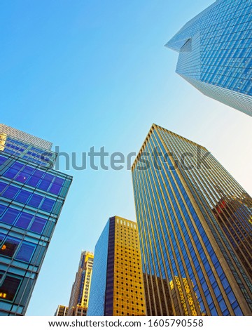Bottom up Street view on Financial District of Lower Manhattan, New York City, NYC, USA. Skyscrapers tall glass buildings United States of America. Blue sky. Empty place for copy space. Mixed media.