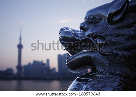 Close-up of traditional Chinese statue with Shanghai skyline in the background