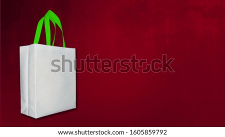 white Shopping Bag. Non Woven Fabric white Bag on dark red Background. 