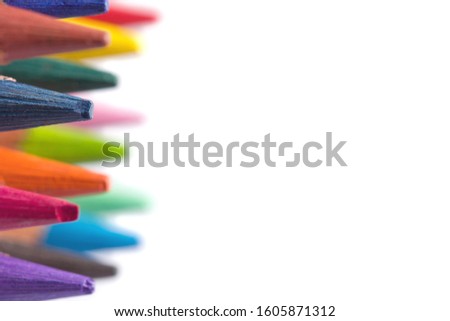 Multi-colored pencils of colored pencils in close-up isolated on a white background with copy space. Close-up sharpened wooden art pencils with place for inscription and text.