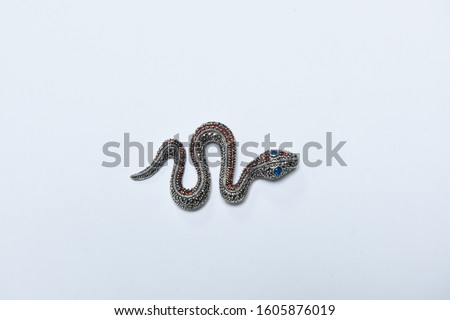 Handcrafted antique brooch in the shape of a snake with colorful stones