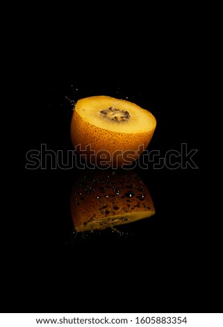 water drop on kiwi fruit in black background. Royalty-Free Stock Photo #1605883354