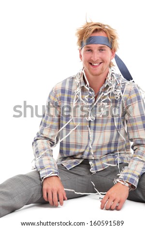 Young attractive party guy with a tie around his head, wearing a shirt and grey pants. White background.