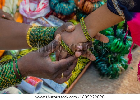 Stock photo of a hand of Indian girl or women wearing green color glass bangles, picture captured at the time of Indian wedding season at  Maharashtra India.