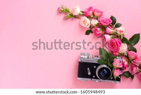 Floral composition with a wreath of pink roses and retro camera on pink background. Valentine's Day background. Flat lay, top view. Royalty-Free Stock Photo #1605948493