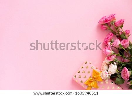 Gift box with beautiful gold ribbon and roses, concept of Valentine's, mother's day and birthday greeting.Valentines day concept. Flat lay, top view, copy space. Royalty-Free Stock Photo #1605948511